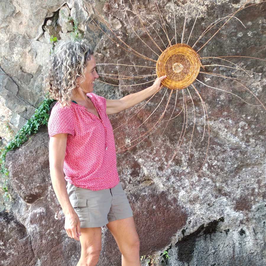 Participante del taller de cestería con su resultado canasta con mano